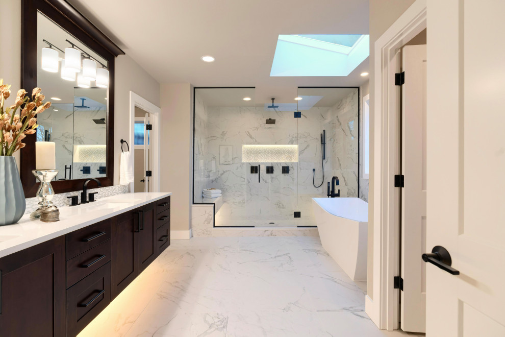 Photo of a large modern master bathroom in Orange County with flat-panel cabinets, brown cabinets, a freestanding tub, an alcove shower, white tile, marble, white walls, marble floors, a drop-in sink, solid surface benchtops, white floor, a hinged shower door, white benchtops, a shower seat, a double vanity, a built-in vanity, wallpaper and wallpaper.
