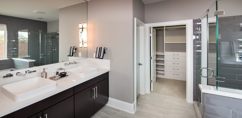 Inspiration for a mid-sized contemporary master bathroom in Houston with a drop-in sink, flat-panel cabinets, dark wood cabinets, quartzite benchtops, a drop-in tub, gray tile, ceramic tile, grey walls and ceramic floors.