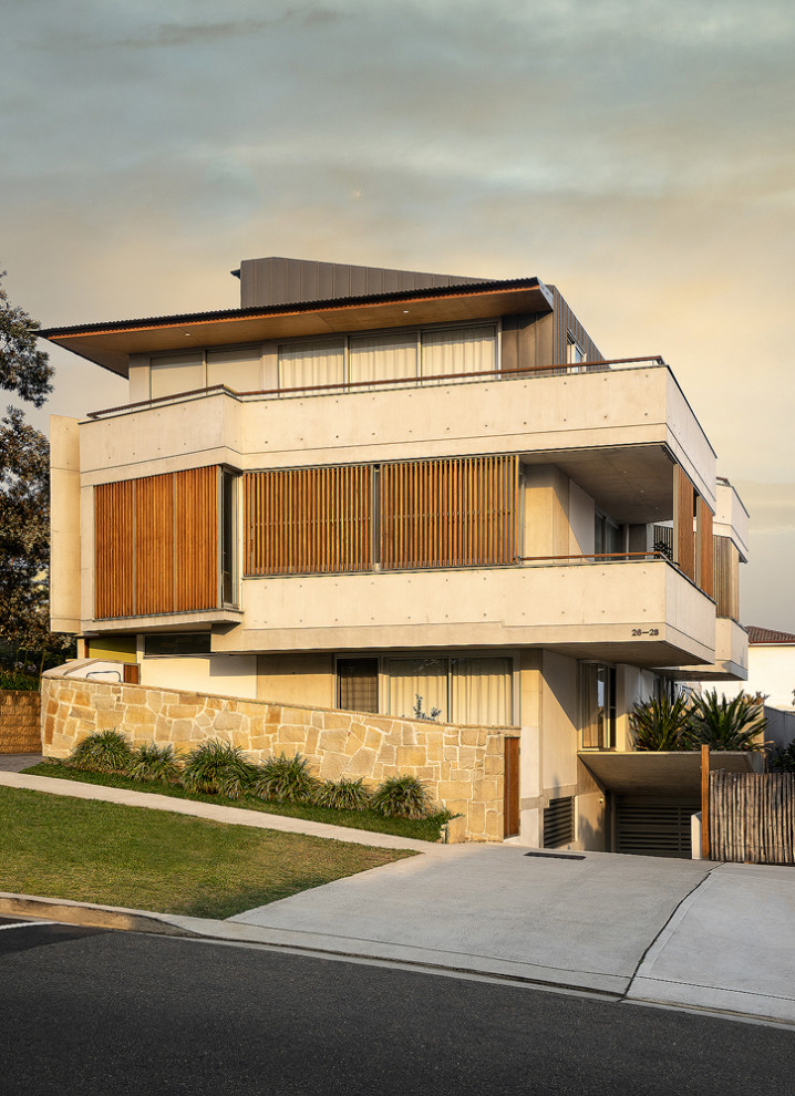 Photo of a modern three-storey concrete apartment exterior in Sydney with a metal roof.