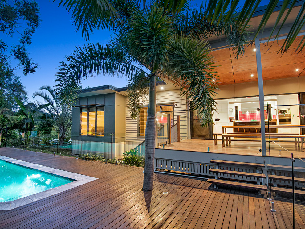 This is an example of a large modern backyard rectangular aboveground pool in Brisbane with natural stone pavers.