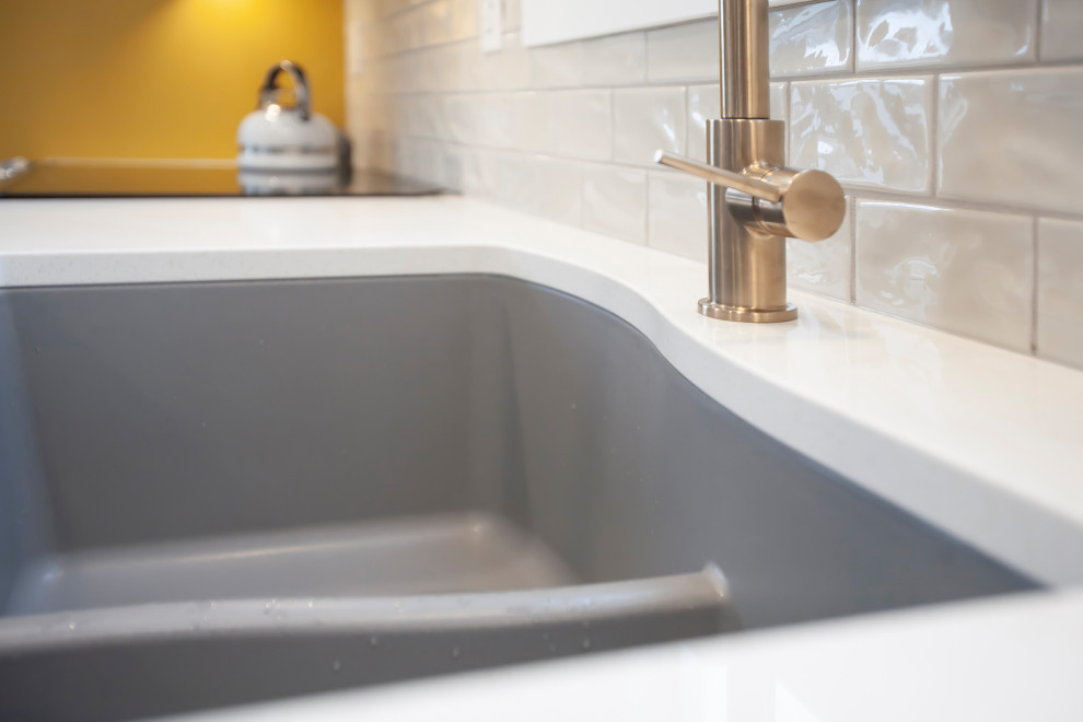Inspiration for a mid-sized transitional single-wall eat-in kitchen remodel with an undermount sink, shaker cabinets, white cabinets, quartz countertops, porcelain backsplash, stainless steel appliances, no island and white countertops