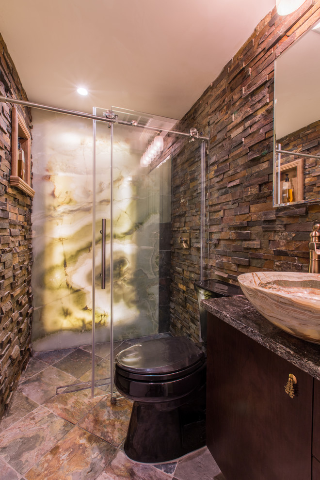 Photo of a mid-sized country 3/4 bathroom in New York with flat-panel cabinets, dark wood cabinets, an alcove shower, a two-piece toilet, brown tile, gray tile, porcelain tile, brown walls, ceramic floors, a vessel sink and granite benchtops.