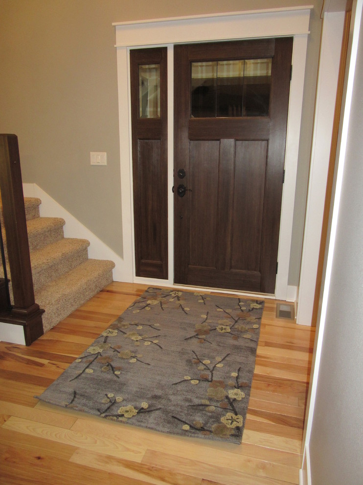 Inspiration for a transitional light wood floor home design remodel with gray walls and a dark wood front door