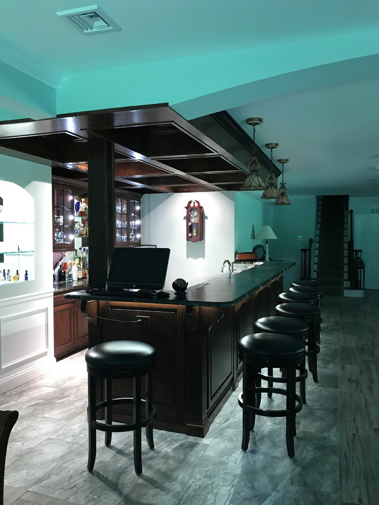 Design ideas for a large traditional seated home bar in Other with raised-panel cabinets, dark wood cabinets and granite benchtops.