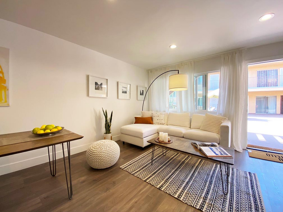 Foto di un piccolo soggiorno minimal aperto con pareti bianche, pavimento in legno massello medio e pavimento grigio