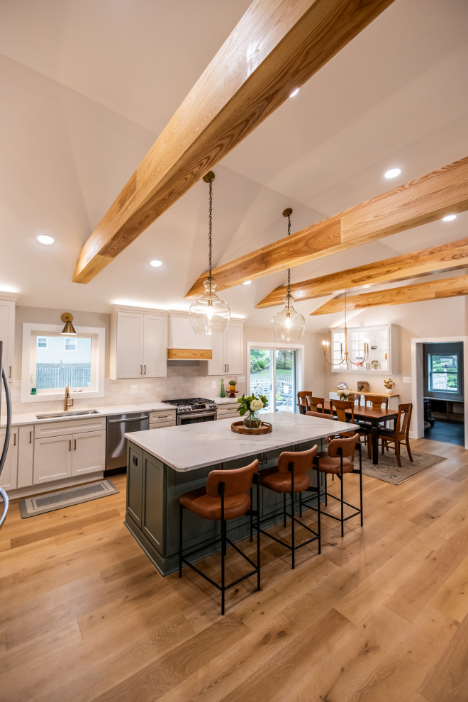 Example of a large transitional l-shaped light wood floor, brown floor and exposed beam eat-in kitchen design in DC Metro with an undermount sink, shaker cabinets, quartz countertops, white backsplash, porcelain backsplash, stainless steel appliances, an island and white countertops