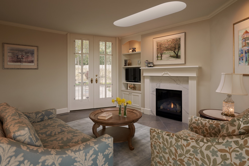 Inspiration for a mid-sized traditional open concept family room in Seattle with porcelain floors, a standard fireplace, beige walls, a tile fireplace surround and a freestanding tv.