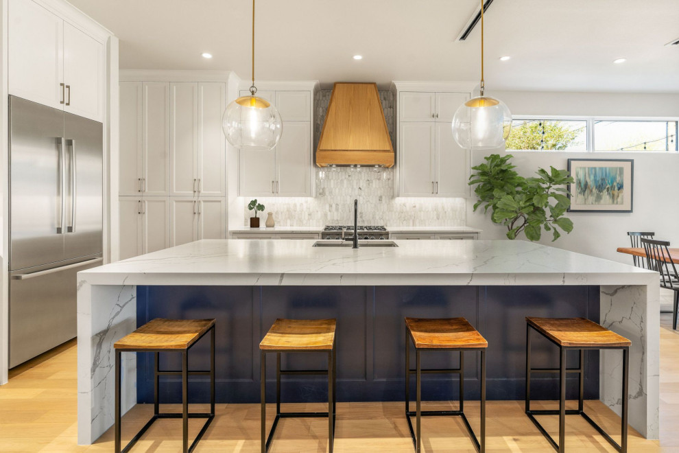 Design ideas for a large transitional eat-in kitchen in Dallas with an undermount sink, shaker cabinets, white cabinets, quartz benchtops, white splashback, marble splashback, stainless steel appliances, light hardwood floors, with island, beige floor and white benchtop.