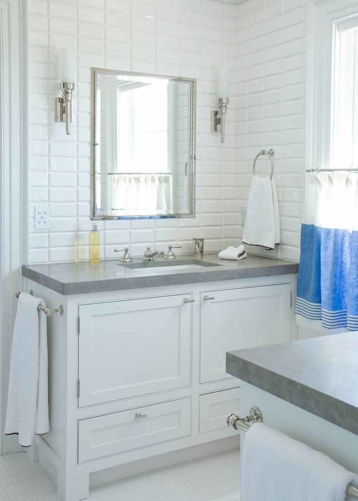 Traditional bathroom in New York with white cabinets, white tile, mosaic tile floors, shaker cabinets and grey benchtops.