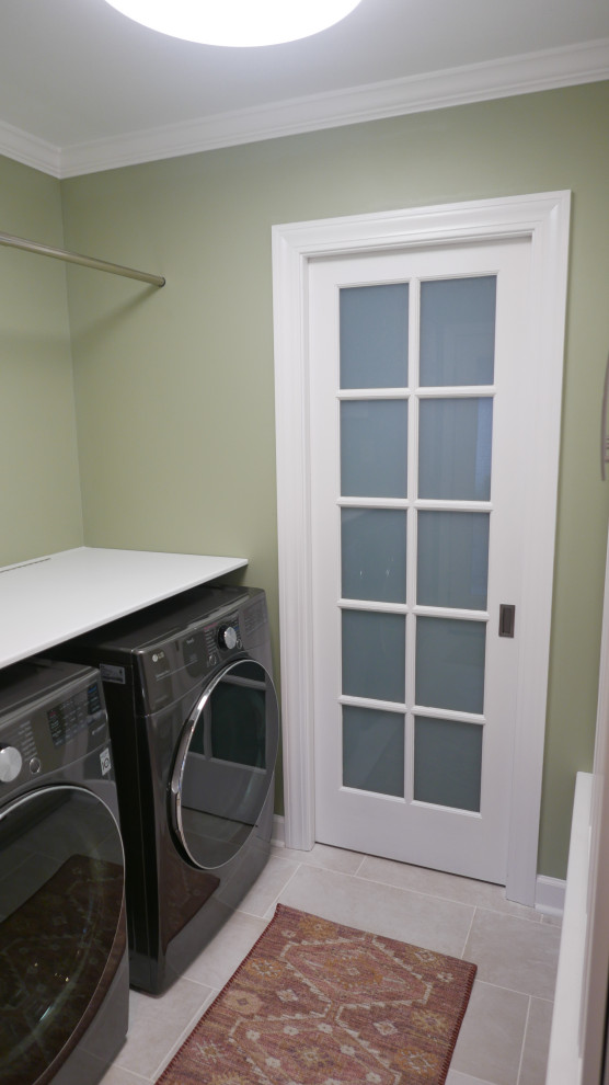 Design ideas for a mid-sized transitional galley utility room in Other with shaker cabinets, white cabinets, green walls, porcelain floors, a side-by-side washer and dryer and beige floor.