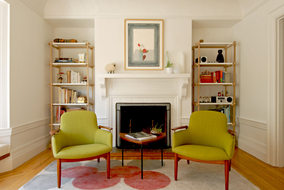 Photo of a midcentury enclosed living room in San Francisco with medium hardwood floors and a standard fireplace.