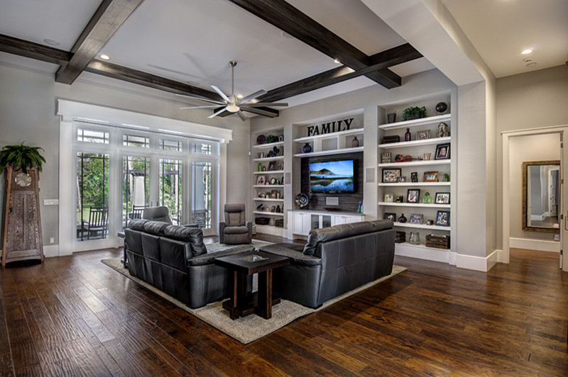 Photo of a large arts and crafts open concept family room in Miami with a library, grey walls, dark hardwood floors, no fireplace and a wall-mounted tv.