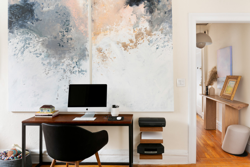 Small scandinavian home office in New York with beige walls and medium hardwood floors.