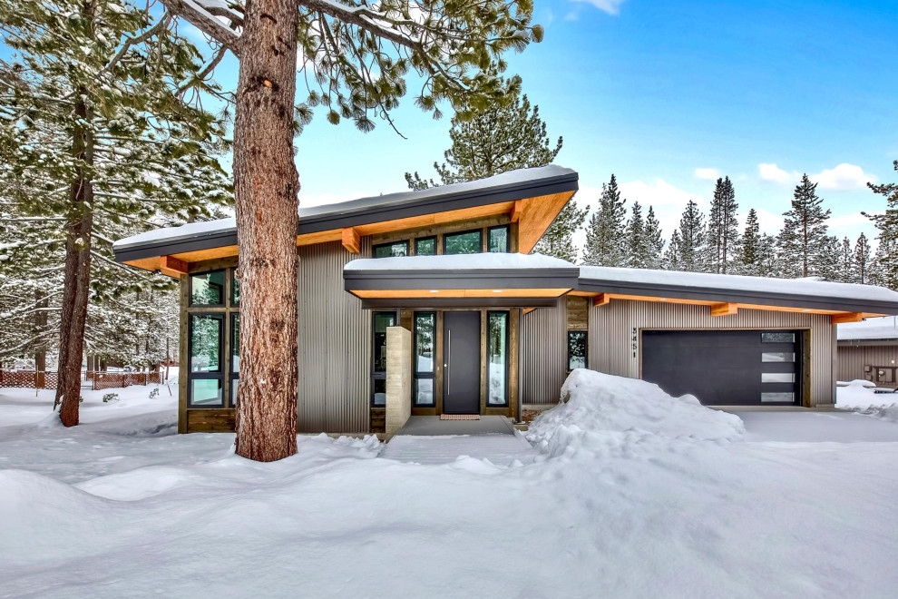 Example of a large trendy gray one-story house exterior design in Other with a shed roof