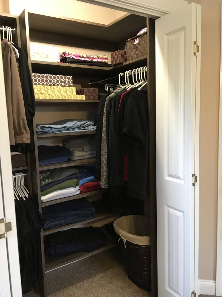 Inspiration for a small transitional gender-neutral carpeted reach-in closet remodel with flat-panel cabinets and dark wood cabinets