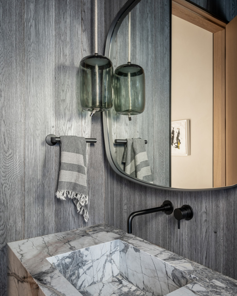 Ejemplo de aseo flotante rural pequeño con paredes grises, lavabo integrado, encimera de mármol y madera