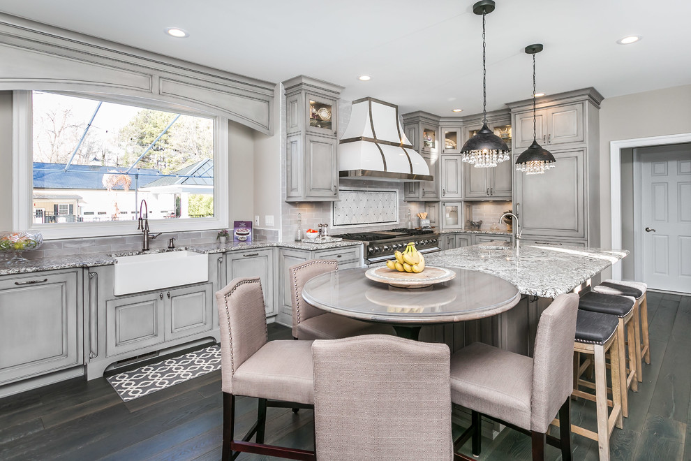 Large traditional u-shaped eat-in kitchen in Baltimore with a farmhouse sink, beaded inset cabinets, grey cabinets, granite benchtops, grey splashback, white appliances, medium hardwood floors, with island and grey floor.