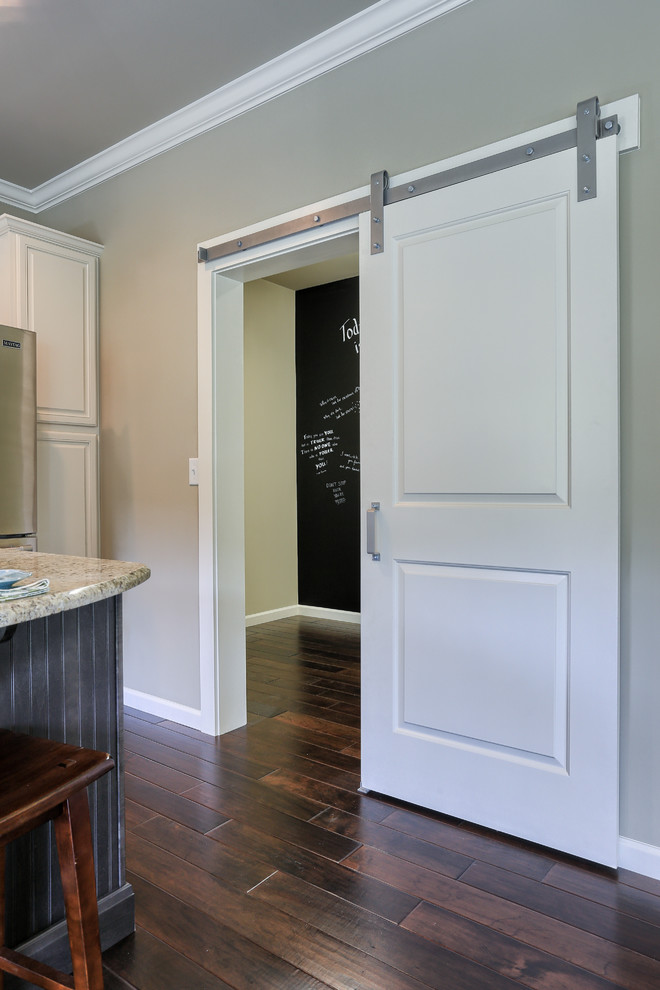 This is an example of a mid-sized traditional dedicated laundry room in Other with dark hardwood floors and grey walls.