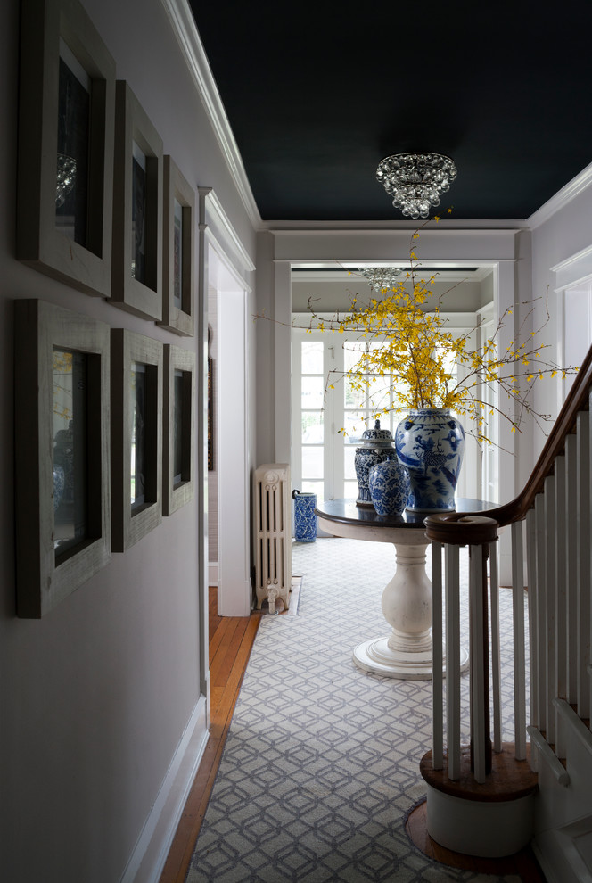 Design ideas for a mid-sized traditional foyer in DC Metro with white walls and medium hardwood floors.