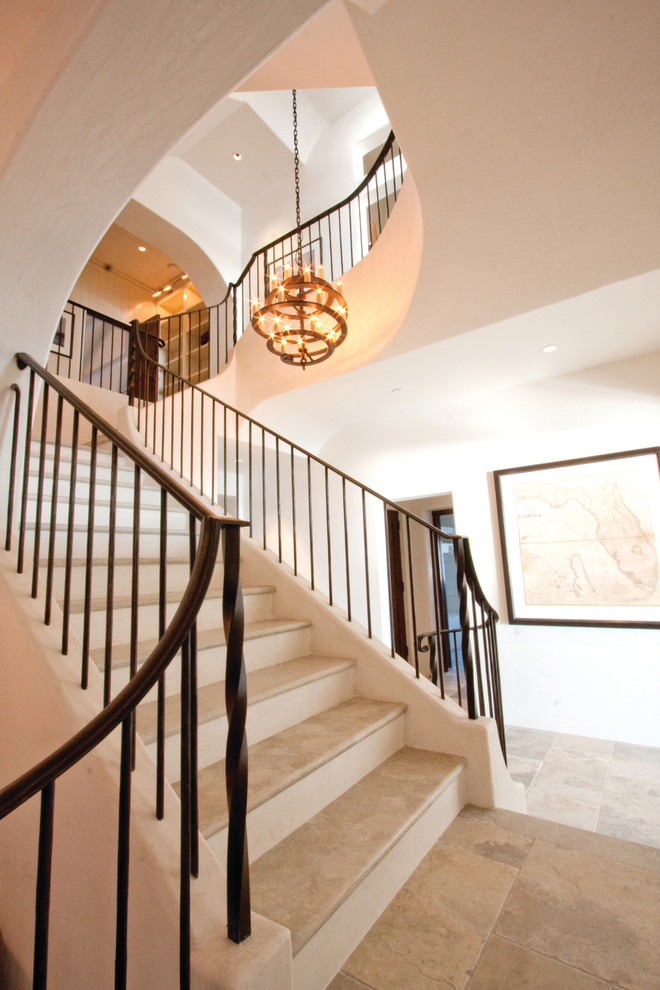 Design ideas for a tropical travertine staircase in Atlanta with metal railing.