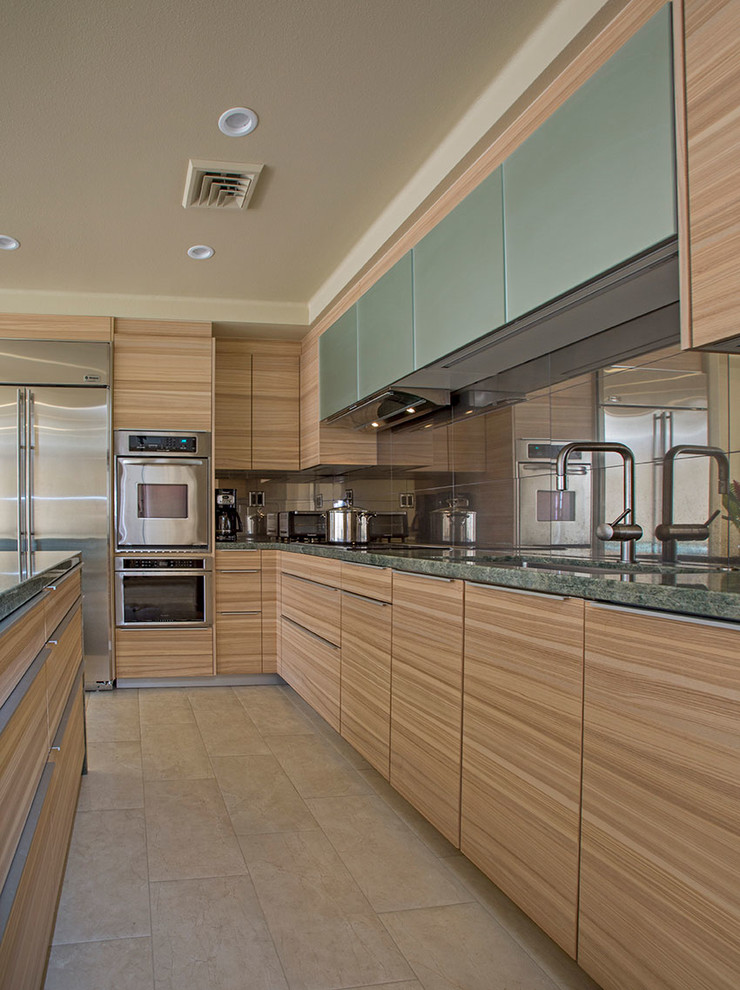 Design ideas for a contemporary kitchen in Hawaii with a single-bowl sink, flat-panel cabinets, medium wood cabinets, granite benchtops, metallic splashback, porcelain splashback, stainless steel appliances and porcelain floors.