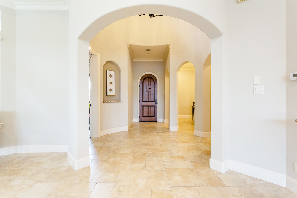 Design ideas for a large mediterranean front door in Houston with grey walls, limestone floors, a single front door, a medium wood front door and beige floor.