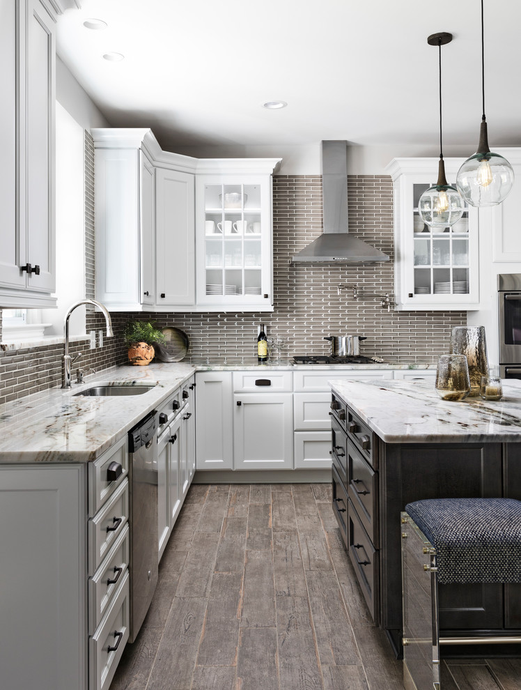 Inspiration for a transitional l-shaped kitchen in Other with an undermount sink, glass-front cabinets, white cabinets, grey splashback, stainless steel appliances, with island and grey floor.