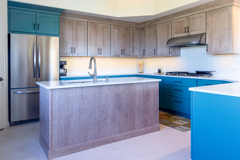 Eat-in kitchen - mid-sized transitional u-shaped porcelain tile and beige floor eat-in kitchen idea with an undermount sink, flat-panel cabinets, turquoise cabinets, quartzite countertops, white backsplash, glass tile backsplash, stainless steel appliances, an island and turquoise countertops