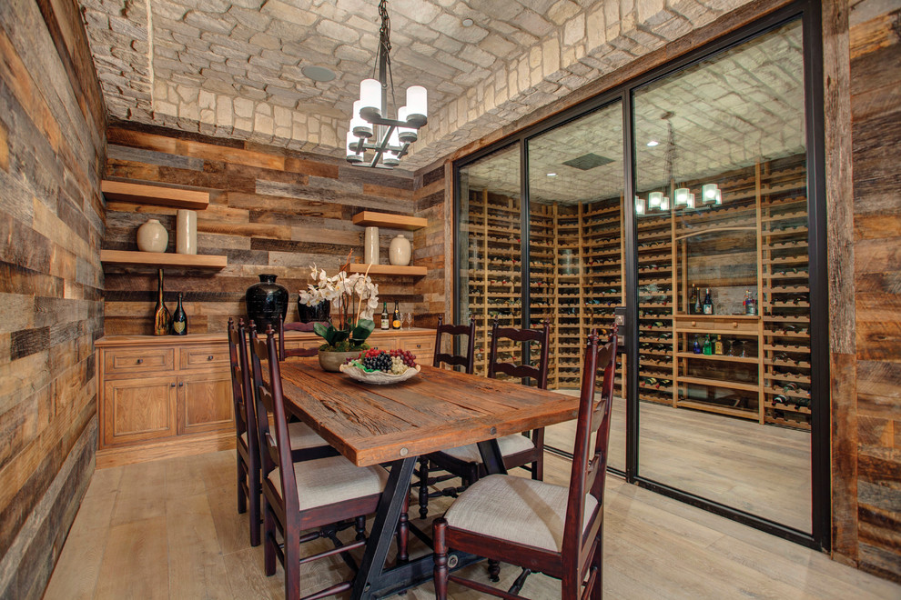 Mediterranean wine cellar in Orange County with light hardwood floors and storage racks.