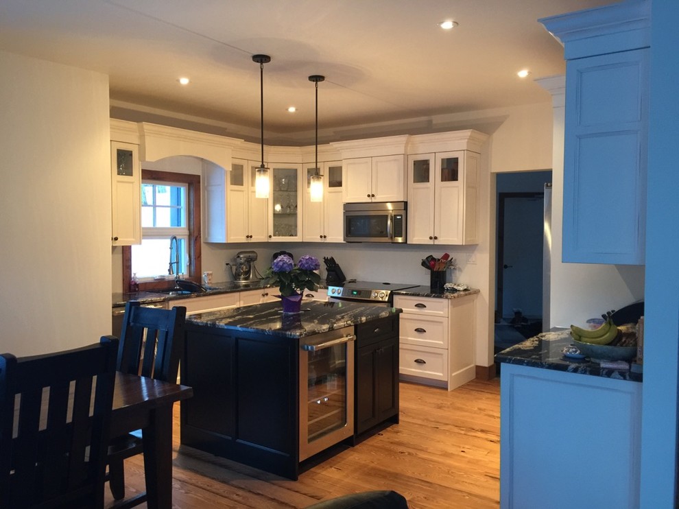 Inspiration for a mid-sized l-shaped kitchen remodel in Toronto with an undermount sink, distressed cabinets, granite countertops, white backsplash, stainless steel appliances and an island
