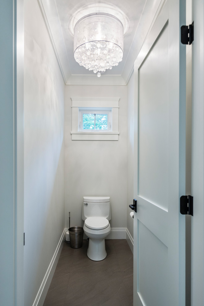 Photo of a large traditional powder room in Vancouver with flat-panel cabinets, brown cabinets, a one-piece toilet, black tile, porcelain tile, white walls, porcelain floors, an undermount sink, granite benchtops and grey floor.