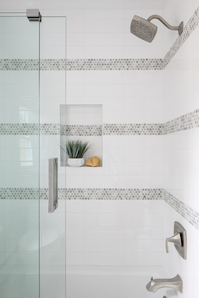Klassisk inredning av ett mellanstort badrum, med blå skåp, ett badkar i en alkov, en dusch/badkar-kombination, grå kakel, grå väggar, marmorgolv, marmorbänkskiva och dusch med skjutdörr