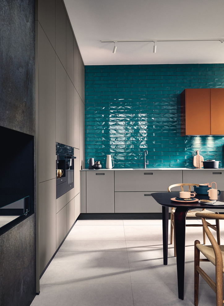 Inspiration for a large contemporary l-shaped eat-in kitchen in Nuremberg with glass-front cabinets, grey cabinets, glass benchtops, black appliances, no island, grey floor and grey benchtop.