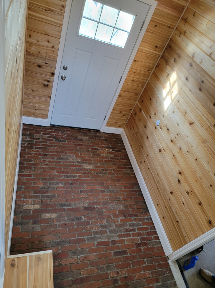 Design ideas for a small country mudroom in Columbus with brick floors, wood and wood walls.