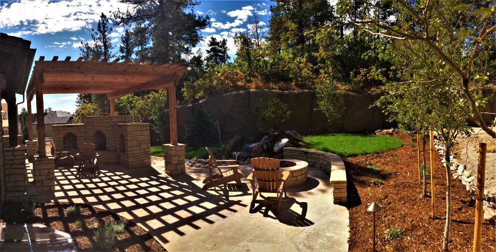 Mid-sized contemporary backyard patio in Denver with with fireplace and natural stone pavers.