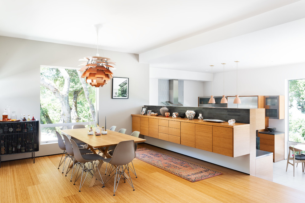 Inspiration for a midcentury open plan dining in San Francisco with white walls, medium hardwood floors and brown floor.