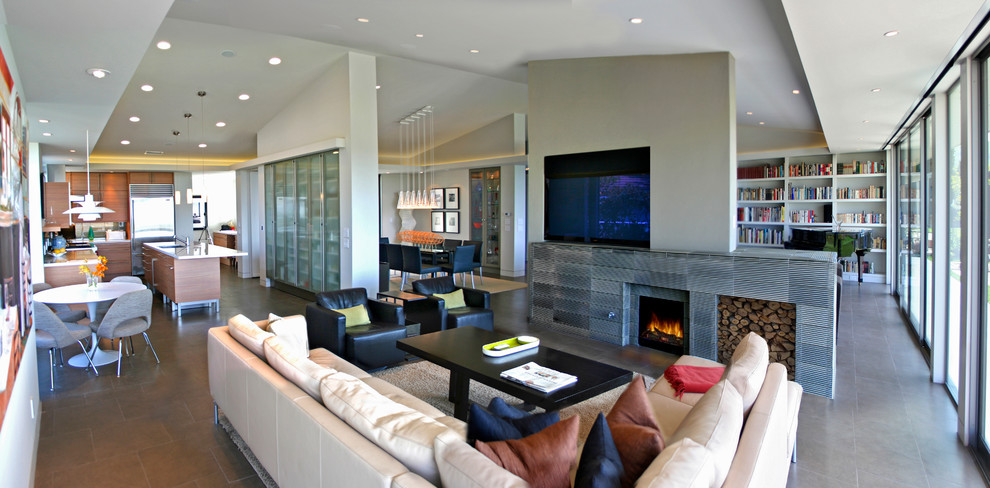 This is an example of a large midcentury open concept living room in Orange County with white walls, porcelain floors, a tile fireplace surround, a built-in media wall and a standard fireplace.