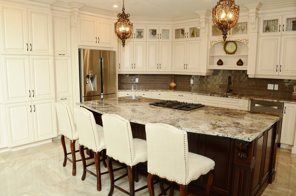 This is an example of a large traditional l-shaped kitchen in Toronto with an undermount sink, raised-panel cabinets, white cabinets, stainless steel appliances, with island, granite benchtops, brown splashback, glass tile splashback and marble floors.