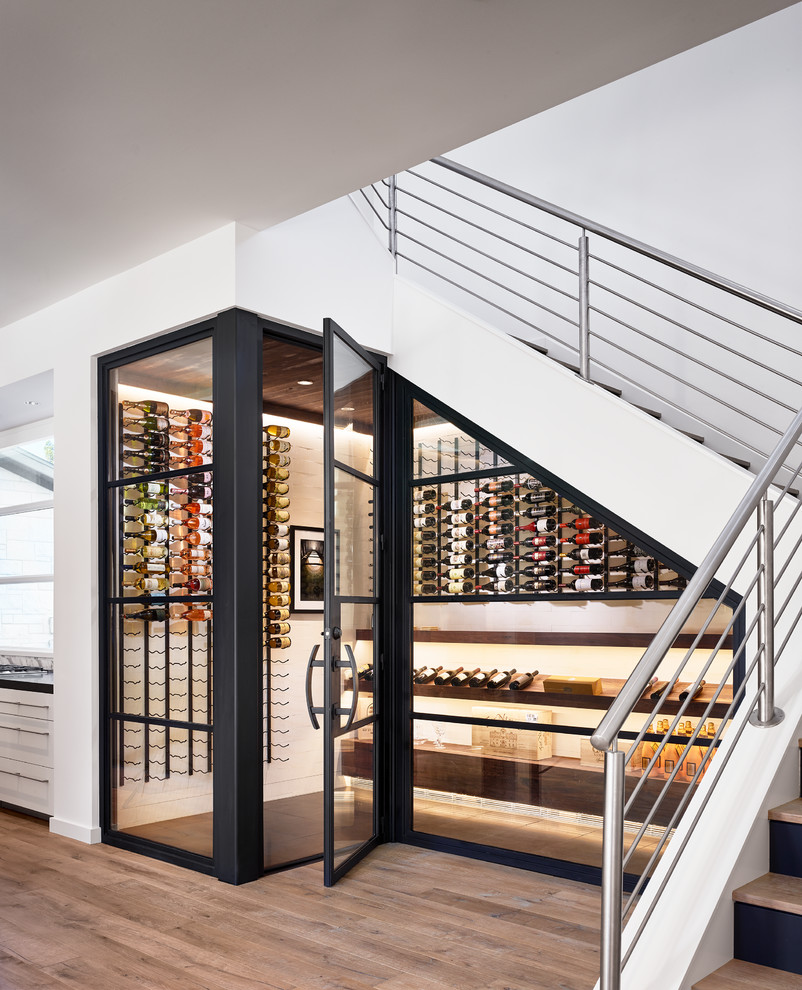 Photo of a contemporary wine cellar in Austin with display racks and beige floor.