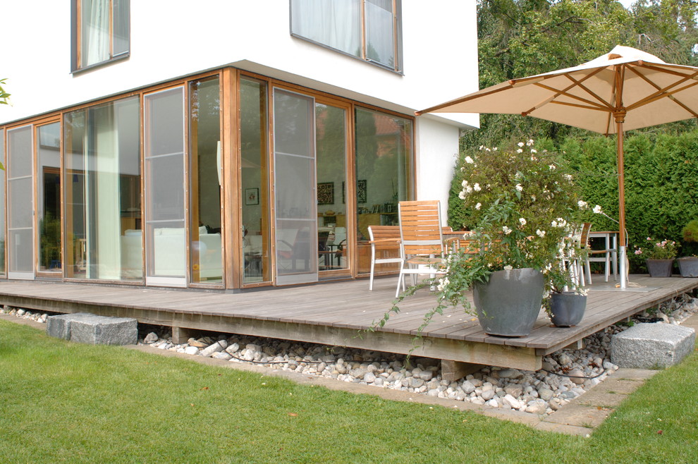 Large contemporary deck in Munich with a container garden and no cover.