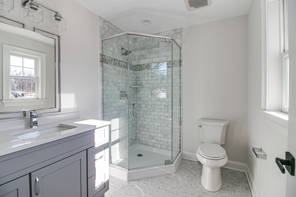 Corner shower - mid-sized transitional 3/4 gray tile and porcelain tile porcelain tile and gray floor corner shower idea in New York with shaker cabinets, gray cabinets, a two-piece toilet, gray walls, an undermount sink, a hinged shower door, white countertops and a built-in vanity