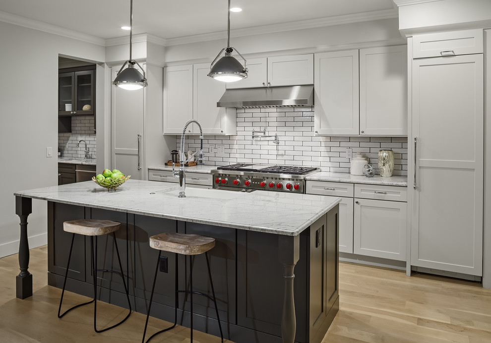 Inspiration for a mid-sized transitional galley kitchen in Denver with an undermount sink, white cabinets, marble benchtops, white splashback, light hardwood floors, with island, beige floor, white benchtop, shaker cabinets, subway tile splashback and stainless steel appliances.