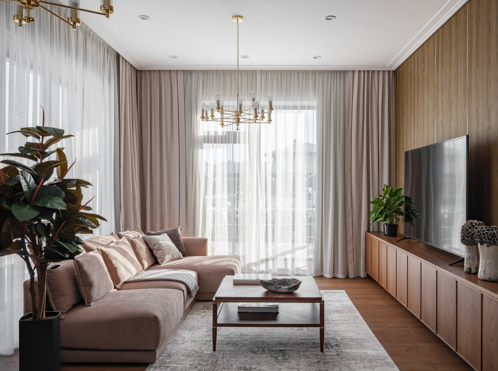 Идея дизайна: гостиная комната в белых тонах с отделкой деревом в современном стиле с бежевыми стенами, паркетным полом среднего тона, телевизором, коричневым полом, любым потолком и панелями на стенах