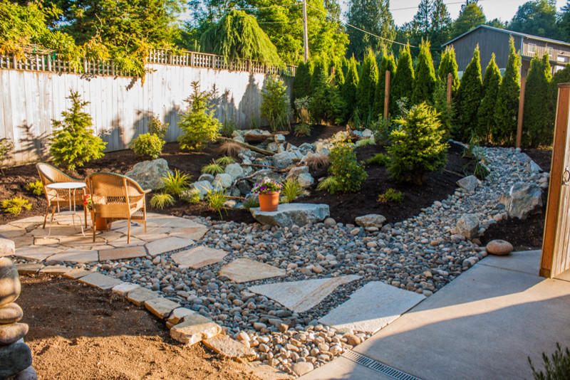 Design ideas for a mid-sized rustic backyard brick water fountain landscape in Seattle with no cover.