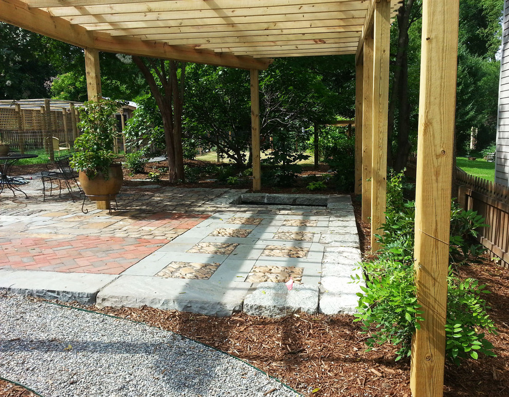 This is an example of a mid-sized eclectic backyard patio in Raleigh with a pergola.