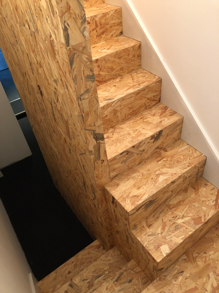 This is an example of a small country wood u-shaped staircase in Nancy with wood risers and wood railing.
