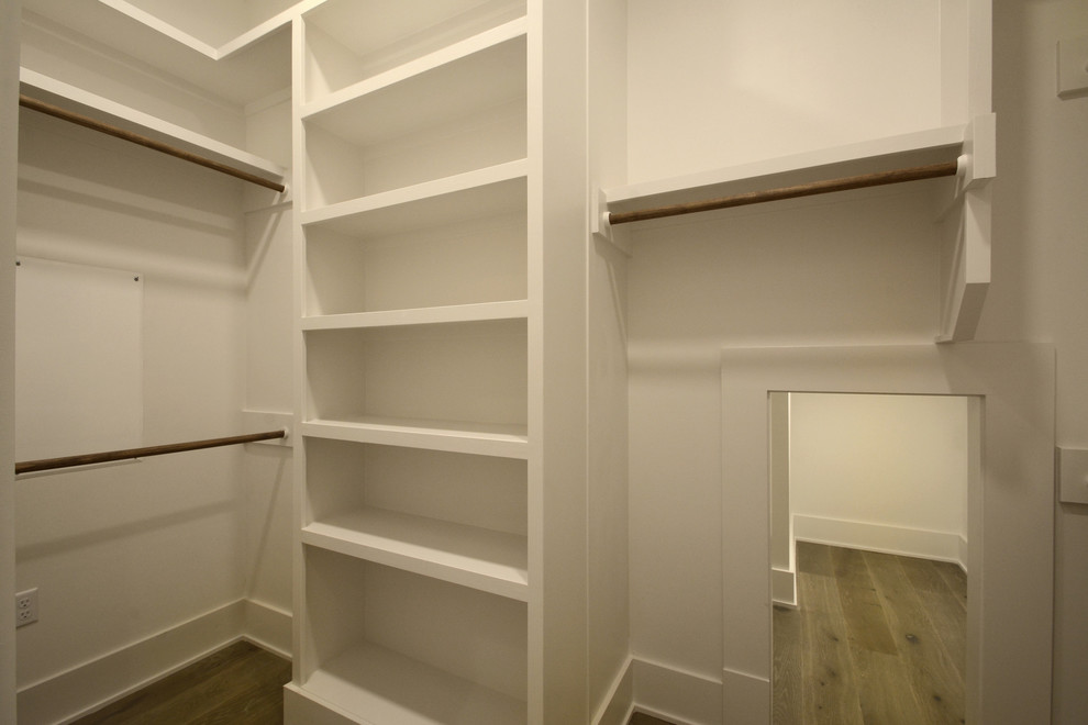 Inspiration for a mid-sized country gender-neutral walk-in wardrobe in Austin with open cabinets, white cabinets, laminate floors and beige floor.