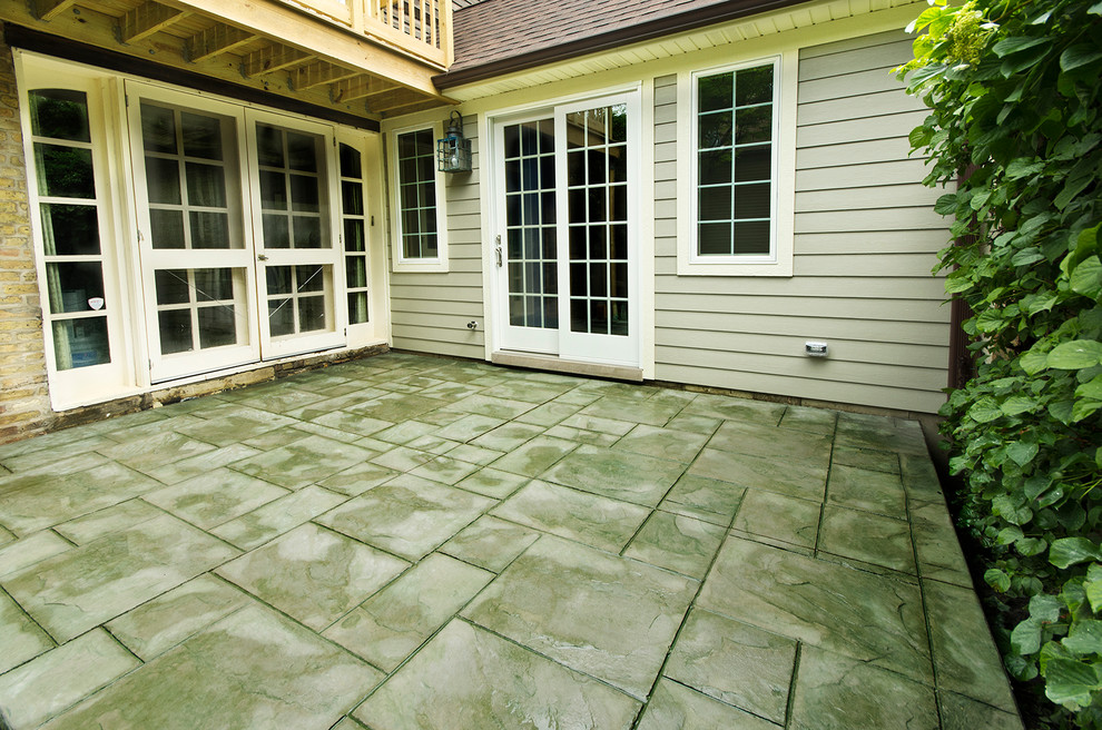 Design ideas for a mid-sized traditional backyard patio in Chicago with stamped concrete and a roof extension.
