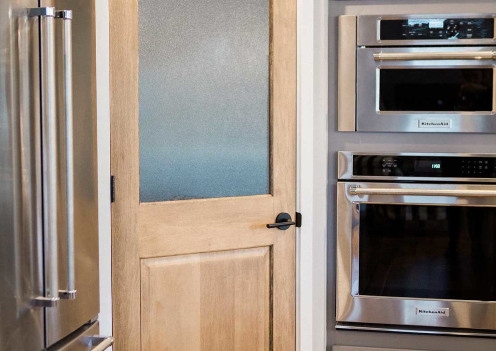 Kitchen - mid-sized transitional kitchen idea with a farmhouse sink, granite countertops, gray backsplash, stainless steel appliances and an island