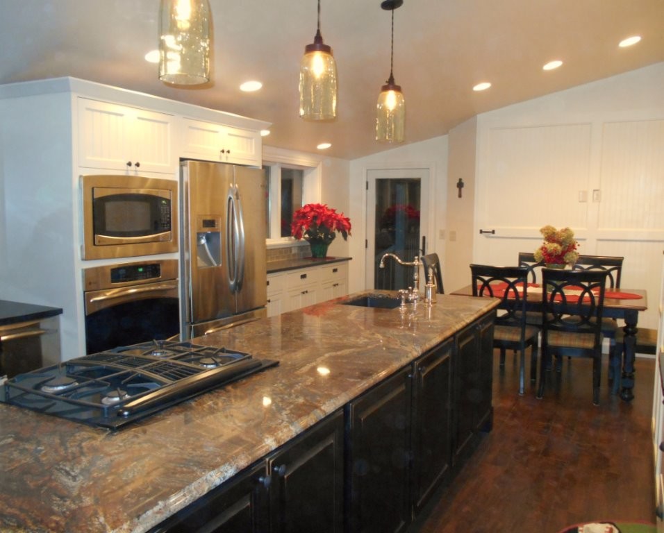 Inspiration for a large transitional u-shaped dark wood floor eat-in kitchen remodel with an undermount sink, recessed-panel cabinets, white cabinets, limestone countertops, stainless steel appliances and an island